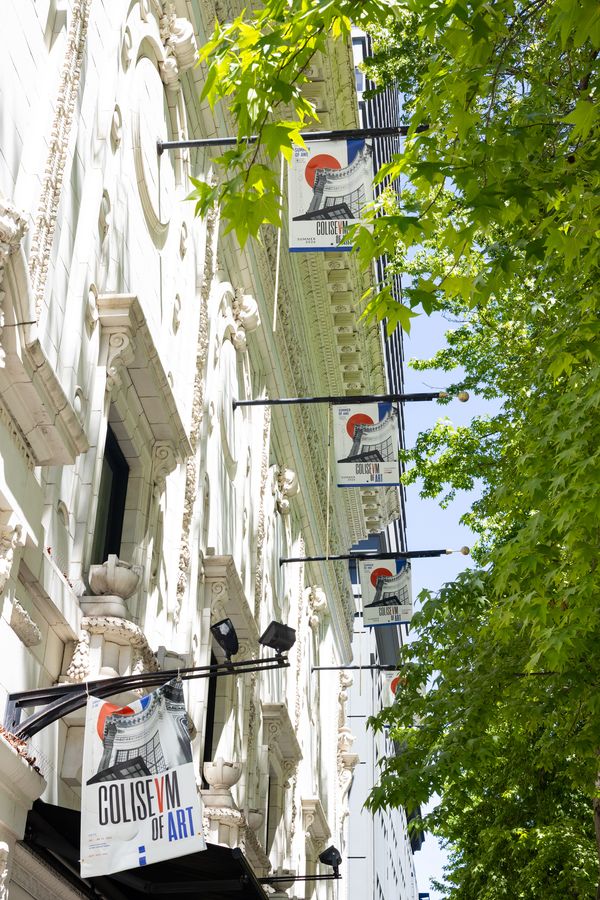 The Colisevm's ornate 1916 terra-cotta facade, hung with Coliseum of Art banners. July 8, 2026.